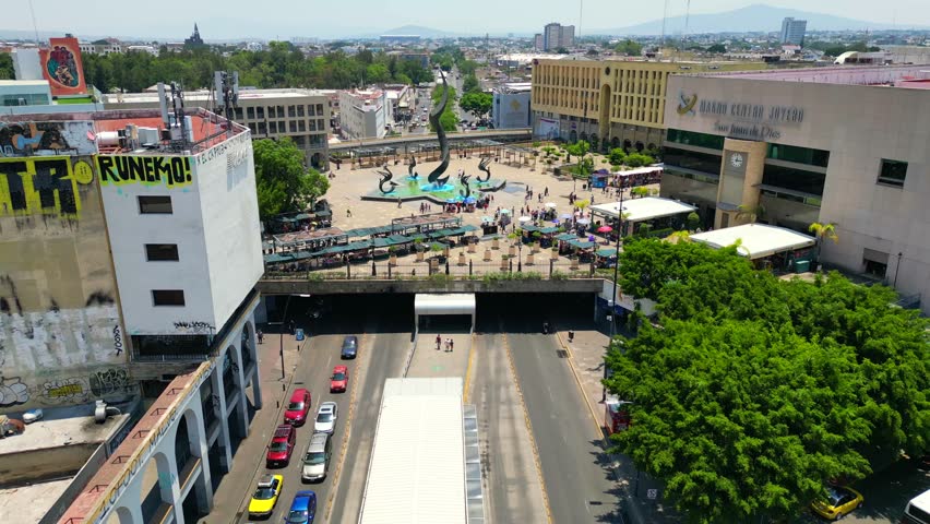 A drone advancing over the streets and flying above the Quetzalcoatl Fountain in Plaza Tapatia, Guadalajara, Mexico