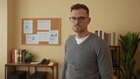 Young man in office smiling confidently in casual attire surrounded by charts and books creating a professional yet relaxed atmosphere in a well-organized workspace. - Powered by Shutterstock - Get 15% off with code: PIKWIZARD15