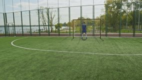 Dolly in shot of Caucasian goalkeeper defending metal goal, trying to catch flying football - Powered by Shutterstock - Get 15% off with code: PIKWIZARD15