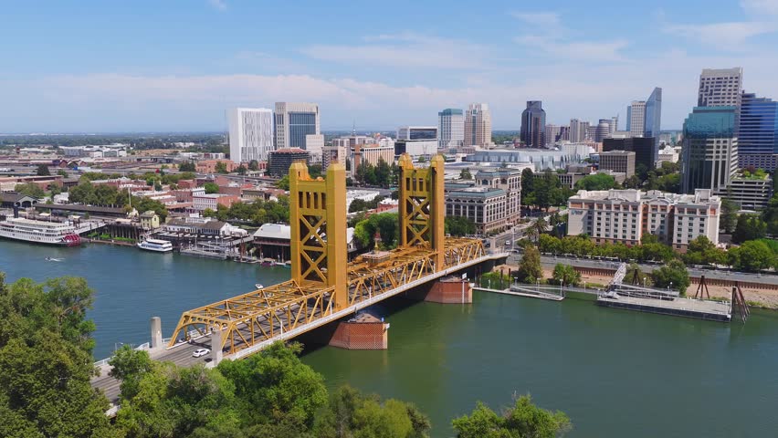Aerial view of Sacramento, California, featuring the Tower Bridge, Sacramento River, downtown skyline, and California State Capitol building.