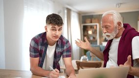 Older grandfather and teenage grandson arguing and having a conflict over school homework at home. Upset senior man is yelling and gesturing while the young student is writing in his notebook - Powered by Shutterstock - Get 15% off with code: PIKWIZARD15