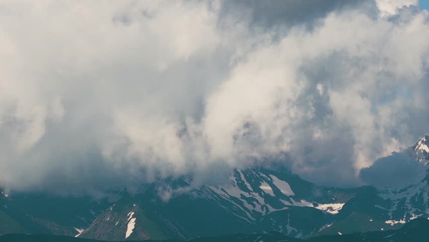Beautiful mountain landscape. High-mountain massif, clouds over mountain peaks. Mountain slope inside a cloud, nature at a height