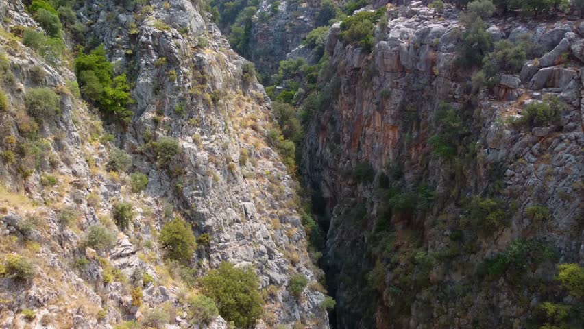 view of the rugged Aradena Gorge in the White Mountains of Crete, Greece, showcasing the deep canyon walls, rocky terrain, and sparse vegetation, characteristic of this famous hiking destination.