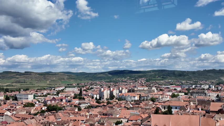 Sibiu UNESCO city old town architecture with traditional red tile rooftops and houses, extending towards the green countryside of Transylvania, Romania