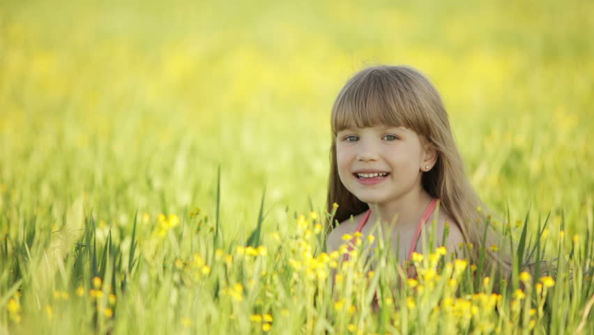 Cute kid lying in field and smiling
