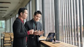 Two businessmen analyze data on a tablet, engaging in a strategic discussion in a contemporary office space - Powered by Shutterstock - Get 15% off with code: PIKWIZARD15