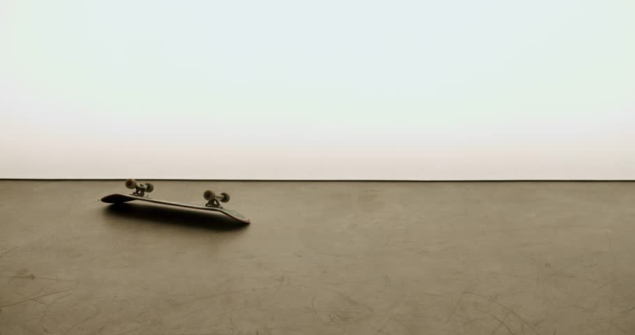 A young skater picks up their skateboard in a minimal studio setting. The bright background and simple environment create a clean look. This is great footage for extreme sports, skateboarding culture,