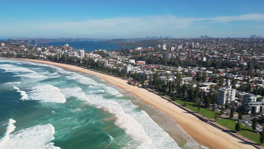 Sydney, Australia : Drone footage of waves in Manly beach northern Sydney, New South Wales, Australia. Showing the seaside resorts and residential area with orbit motion.  