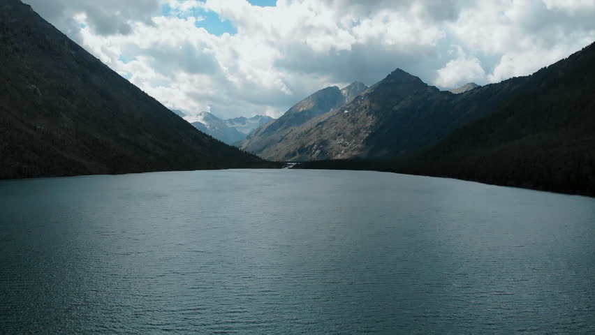 Dramatic mountain lake landscape with moving clouds. Media