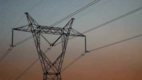 High voltage Power grid tower Electricity pylon stands silhouetted against colorful sunset sky. Power lines transmit electricity. Rural area infrastructure provides power. - Powered by Shutterstock - Get 15% off with code: PIKWIZARD15