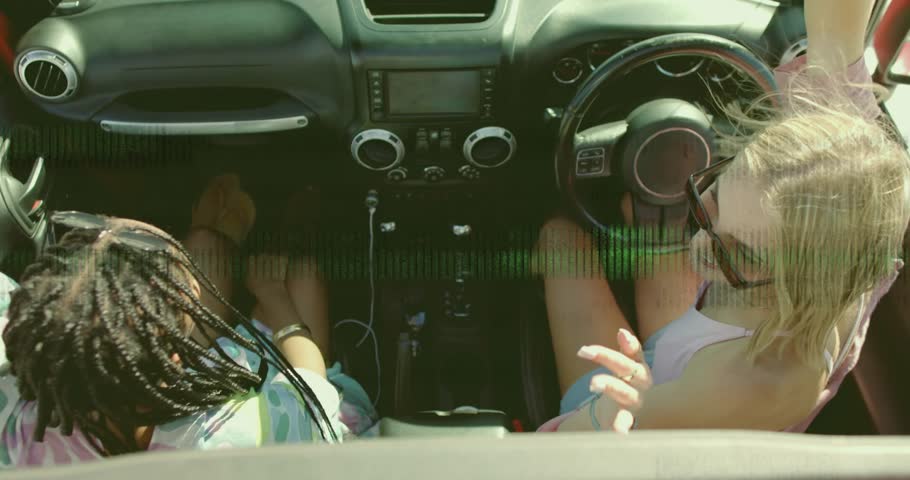 Friends dancing in convertible and making technology content on smartphone after glitch resolving. Joy, adventure, carefree, summer, spontaneity, leisure, vibrancy