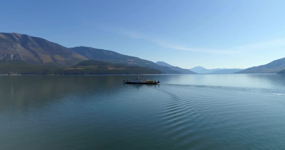 Upon entering frame ferry gliding across lake triangles drifting and shifting demonstrating overlay. Scenery, voyage, tranquility, landscape, reflection, adventure, minimalism