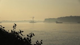 Early morning fog envelops harbor as cranes and a boat create a tranquil atmosphere at sunrise - Powered by Shutterstock - Get 15% off with code: PIKWIZARD15