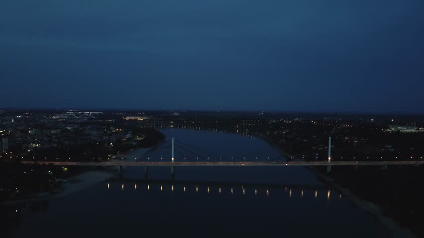 City skyline at night with illuminated bridge and river view showcasing urban tranquility