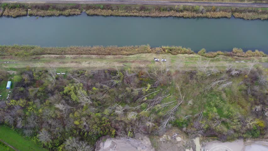 Aerial view of a riverbank area showing fallen trees and natural habitat recovery in a scenic environment