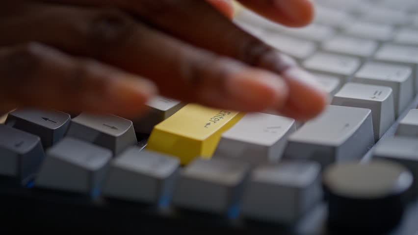 Extreme close-up of hands and fingers of anonymous young black woman with neat natural nail manicure pressing backspace key on desktop computer keyboard while writing or editing text