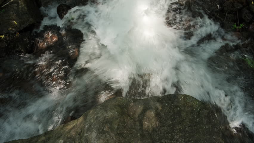 Seething cascade of mountain river falls from rock stone