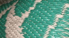 Close-up video of green and white woven plastic carpet, displaying zigzag pattern and detailed durable texture. - Powered by Shutterstock - Get 15% off with code: PIKWIZARD15