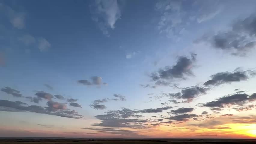 Majestic, Gorgeous, Beautiful Alberta, Canada, sunset sky, with vibrant orange and pink clouds over open prairie landscape, capturing the calm and colourful evening light across the rural horizon.