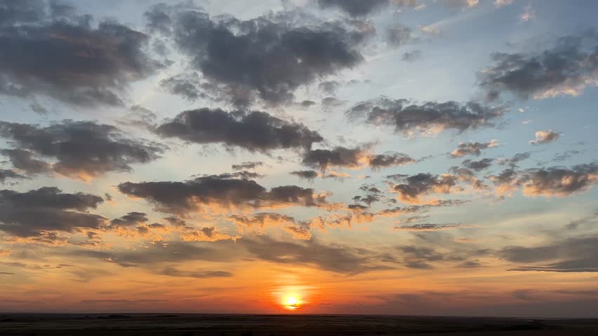 Majestic, Gorgeous, Beautiful Alberta, Canada, sunset sky, with vibrant orange and pink clouds over open prairie landscape, capturing the calm and colourful evening light across the rural horizon.