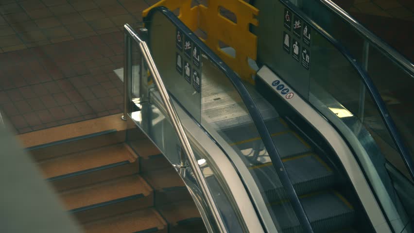 Escalator moving staircase in shopping mall wide top view zoom shot selective focus