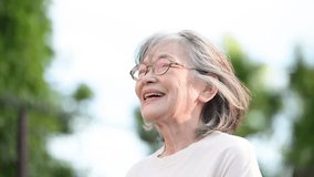 Close-up vertical video of an elderly white-haired woman smiling brightly against the backlight	 - Powered by Shutterstock - Get 15% off with code: PIKWIZARD15