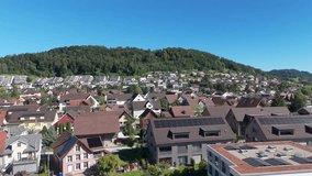 Modern Swiss neighborhood with rooftop solar and efficient housing on a hillside; drone pullback - Powered by Shutterstock - Get 15% off with code: PIKWIZARD15