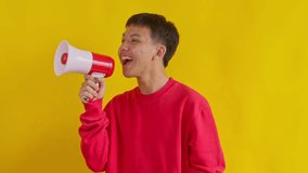 Young man enthusiastically announcing news with megaphone vibrant and energetic isolated on yellow background - Powered by Shutterstock - Get 15% off with code: PIKWIZARD15