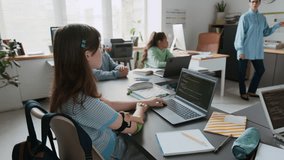 High angle handheld zoom in shot of young girl with prosthetic arm attending programming lesson in modern school classroom - Powered by Shutterstock - Get 15% off with code: PIKWIZARD15