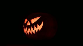 Glowing jack-o'-lantern lit from inside on black background. Halloween concept. UHD 4k video - Powered by Shutterstock - Get 15% off with code: PIKWIZARD15
