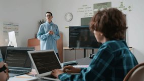 Teenage boy in checkered shirt raising his hand to ask teacher question during programming lesson in school - Powered by Shutterstock - Get 15% off with code: PIKWIZARD15