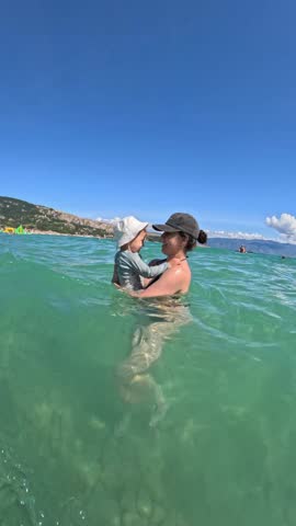 Mother and Toddler son Swimming at Sunny Beach