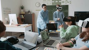 Middle-aged female teacher teaching her students to use VR glasses during IT class in modern school - Powered by Shutterstock - Get 15% off with code: PIKWIZARD15