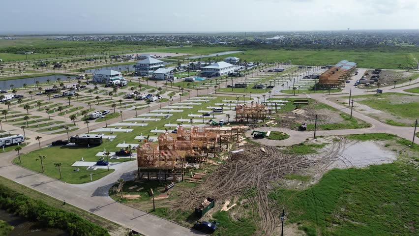Coastal RV resort with dual scenic ponds, timber stilt house construction, palm-lined concrete pads, completed rentals near Galveston, Texas. HOA amenities and vacant land signal phased growth. USA