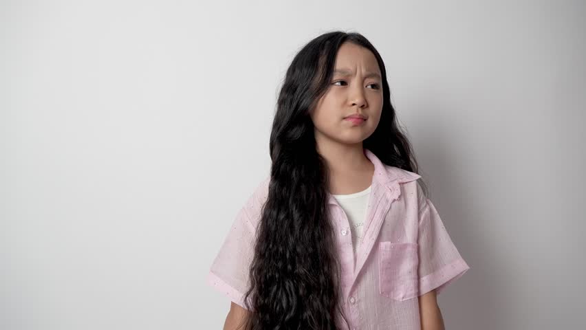 Young girl is squinting her eyes and looking slightly to the side