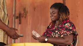 Mobile money (MoMo) agent makes cash withdrawal for customer at outdoor stand. Digital payments, fintech and financial inclusion in Africa. - Powered by Shutterstock - Get 15% off with code: PIKWIZARD15