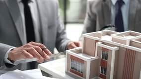 Two men are looking at a model of a house - Powered by Shutterstock - Get 15% off with code: PIKWIZARD15