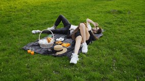 young couple in love lying on blanket on the grass and resting, man and woman relax on picnic in the park - Powered by Shutterstock - Get 15% off with code: PIKWIZARD15