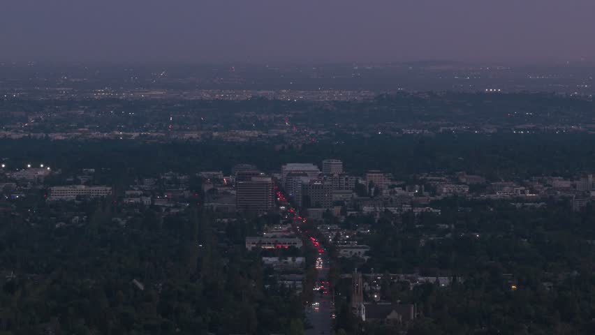 Telephoto aerial descending shot of old town Pasadena as seen from Altadena, California at twilight. 4K