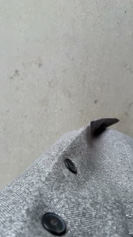 Gray coat and red sneakers walking on pavement from above, providing background imagery video