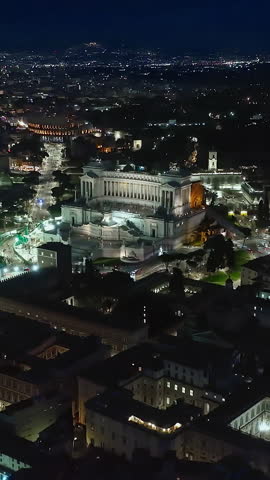  Establishing shot drone flying of historical monument to Vittorio Emanuele II in Rome on Venice Square at night. Downtown Rome, Italy