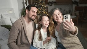 Merry Christmas celebrating. Happy family mother father girl child having video chat in smartphone. Parents kid recording video in social network. Family having video call with friends family - Powered by Shutterstock - Get 15% off with code: PIKWIZARD15