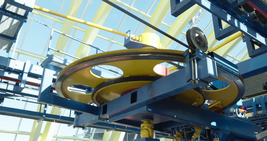 Close-up of gondola lift technology with large rotating wheel and mechanical parts inside a modern station. Concept of engineering, transport, and mountain infrastructure.