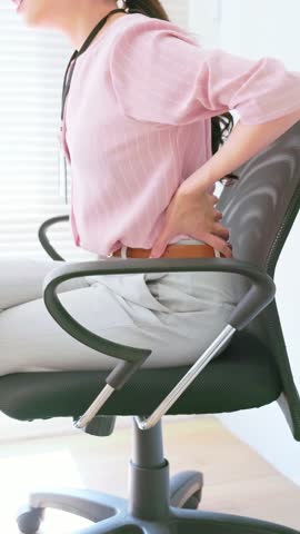 Business Woman Suffering from Lower Back Pain while Sitting at Office Desk