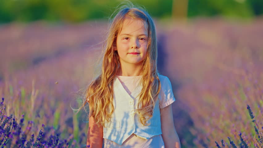 Portrait of a little beautiful girl in blooming lavender field