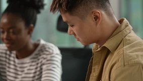 Concentrated Asian man Korean businessman review documents stats financial datum African informal business woman American businesswoman writing notes smiling looking laptop multiethnic colleagues team - Powered by Shutterstock - Get 15% off with code: PIKWIZARD15