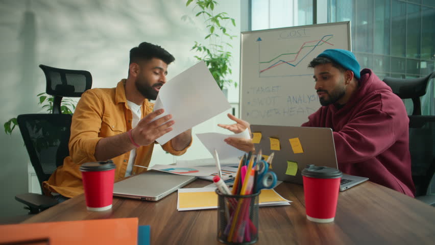 Two stressed arguing disappointed Arabian business men problem with paperwork yelling difficulty meeting in informal casual office working brainstorming conflict document mistake Indian businessmen