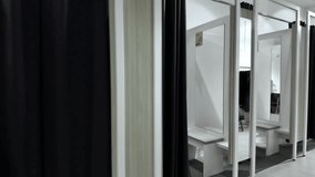 Spacious interior of a modern fashion boutique featuring multiple private changing booths, equipped with mirrors and seating for comfortable customer try-ons - Powered by Shutterstock - Get 15% off with code: PIKWIZARD15