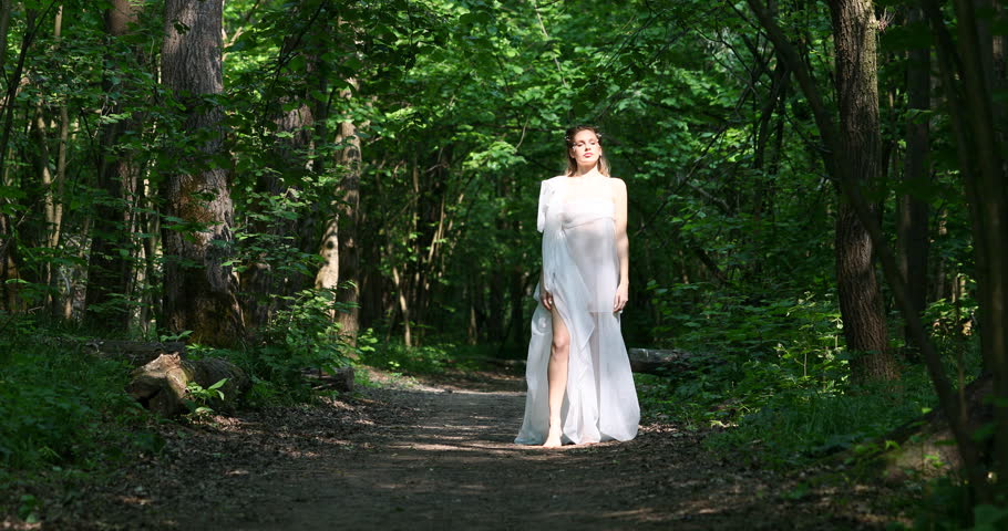 A beautiful girl posing as a nymph in the forest