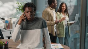 Ethnic project leader African American business man businessman communicate with mobile phone in office on background of diversity coworkers going with computer discuss job multiethnic informal group - Powered by Shutterstock - Get 15% off with code: PIKWIZARD15